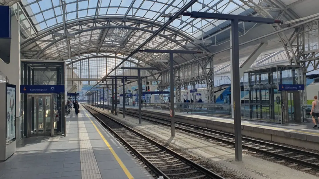Elektrischer Zug unter Fahrleitung in einem modernen Bahnhof